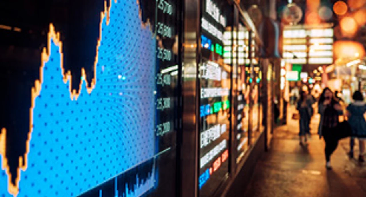 A big display showing a stock chart in a busy street in China
