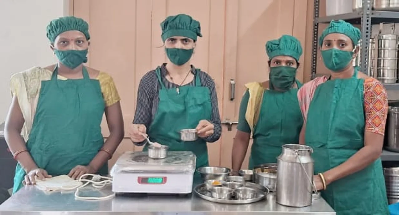 Four Kamla co-operative members wearing green protective clothing