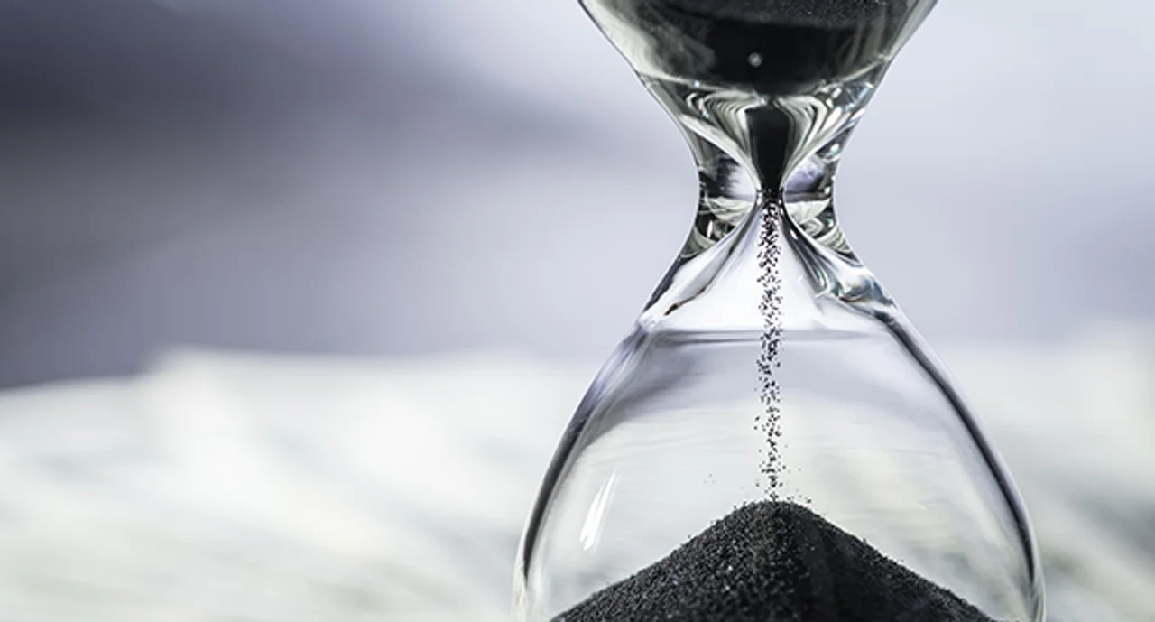 Closed Up Of Sand Falling In Sandglass Or Hourglass On Us Dollar Bills