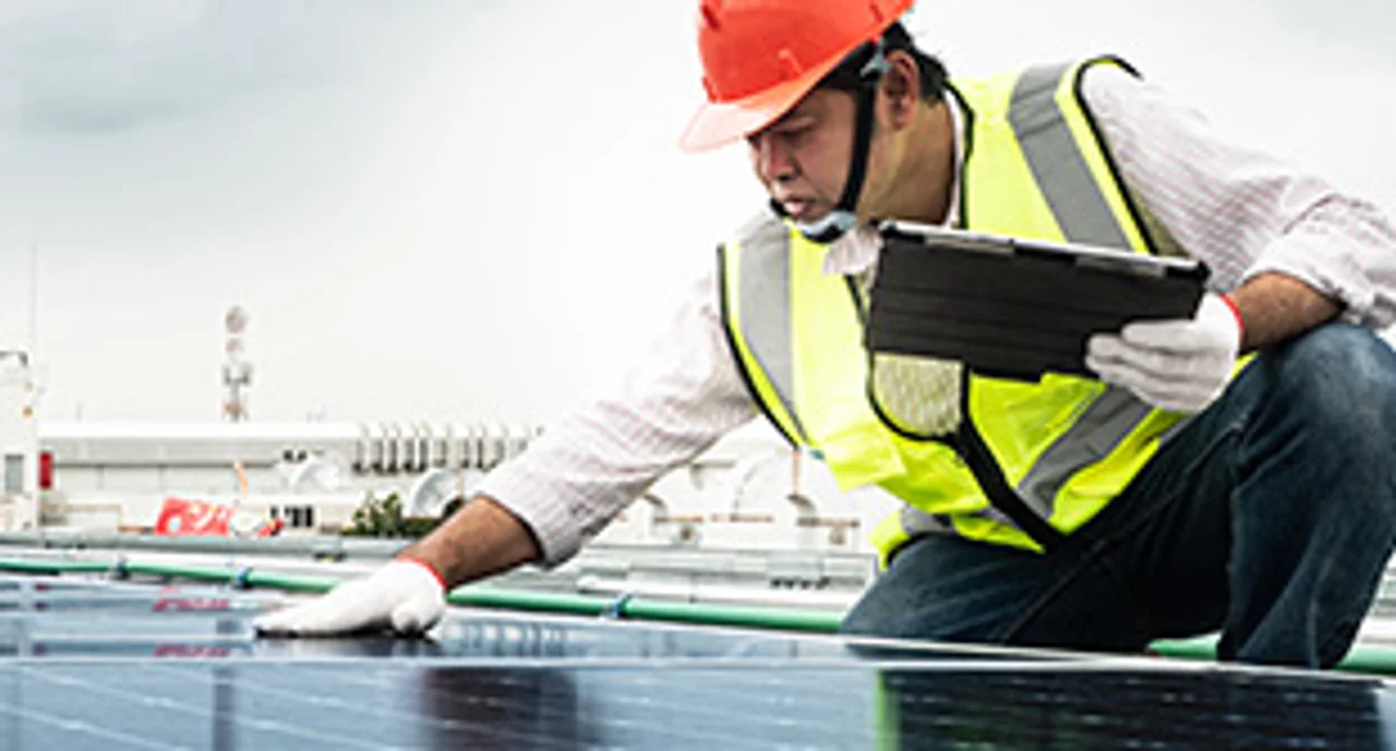 Male engineer checks a photovoltaic (solar) plant and uses a recording