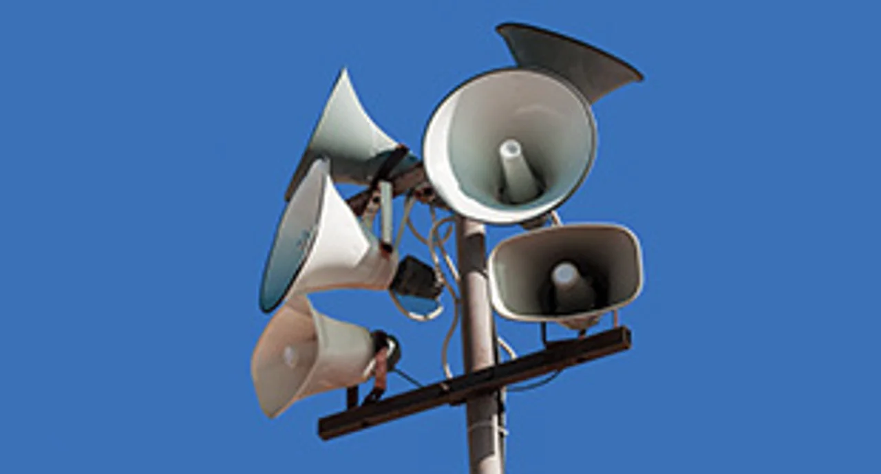Set of street loudspeakers on a pole on background blue sky