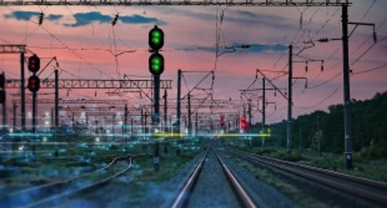 Train tracks, lights, and cables in the sunset