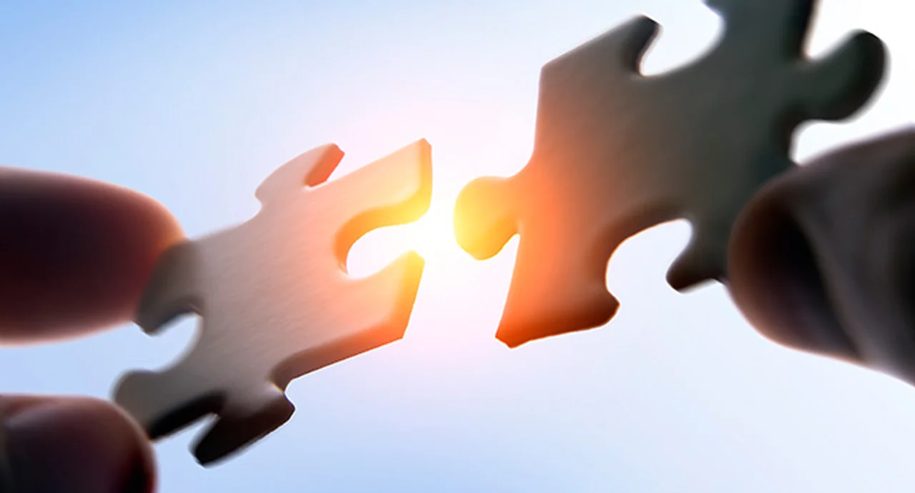 Putting puzzle pieces together on sky background with sunlight