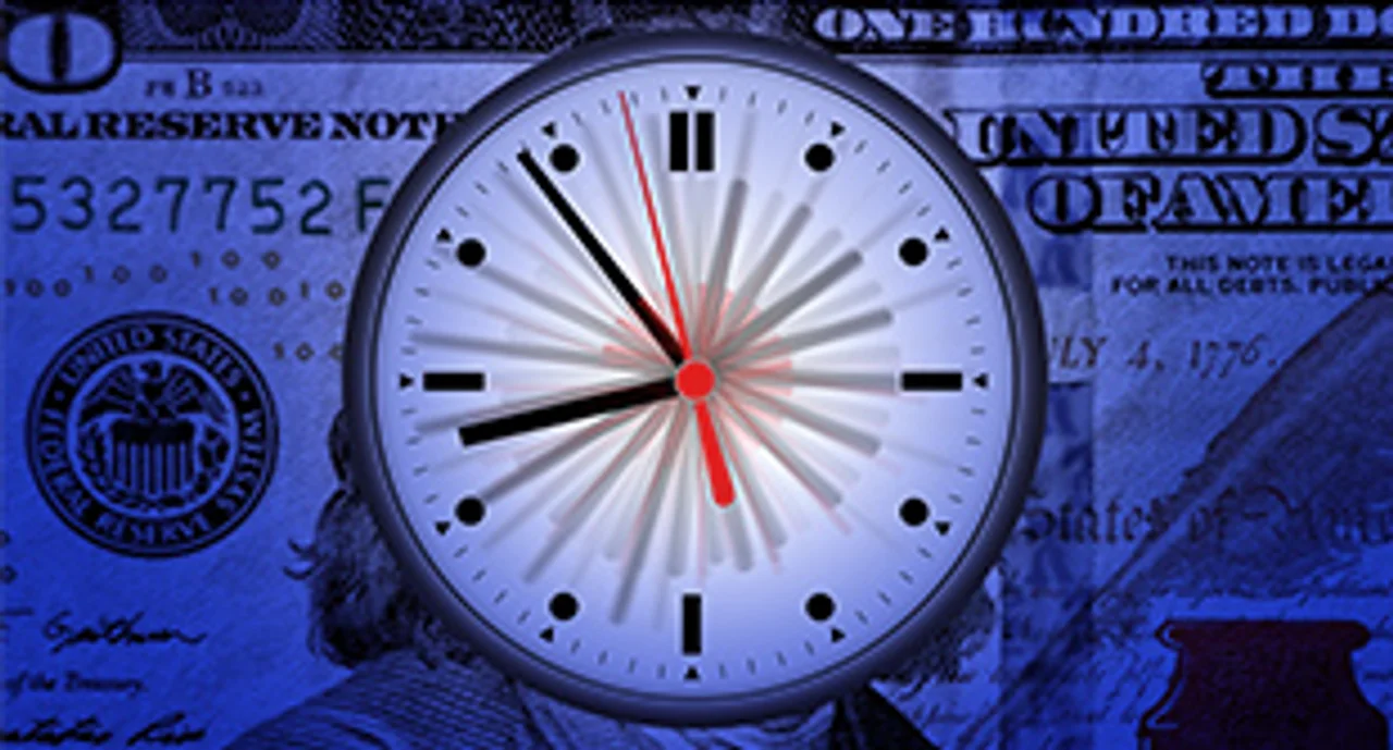 A clock in front of a hundred dollar bill