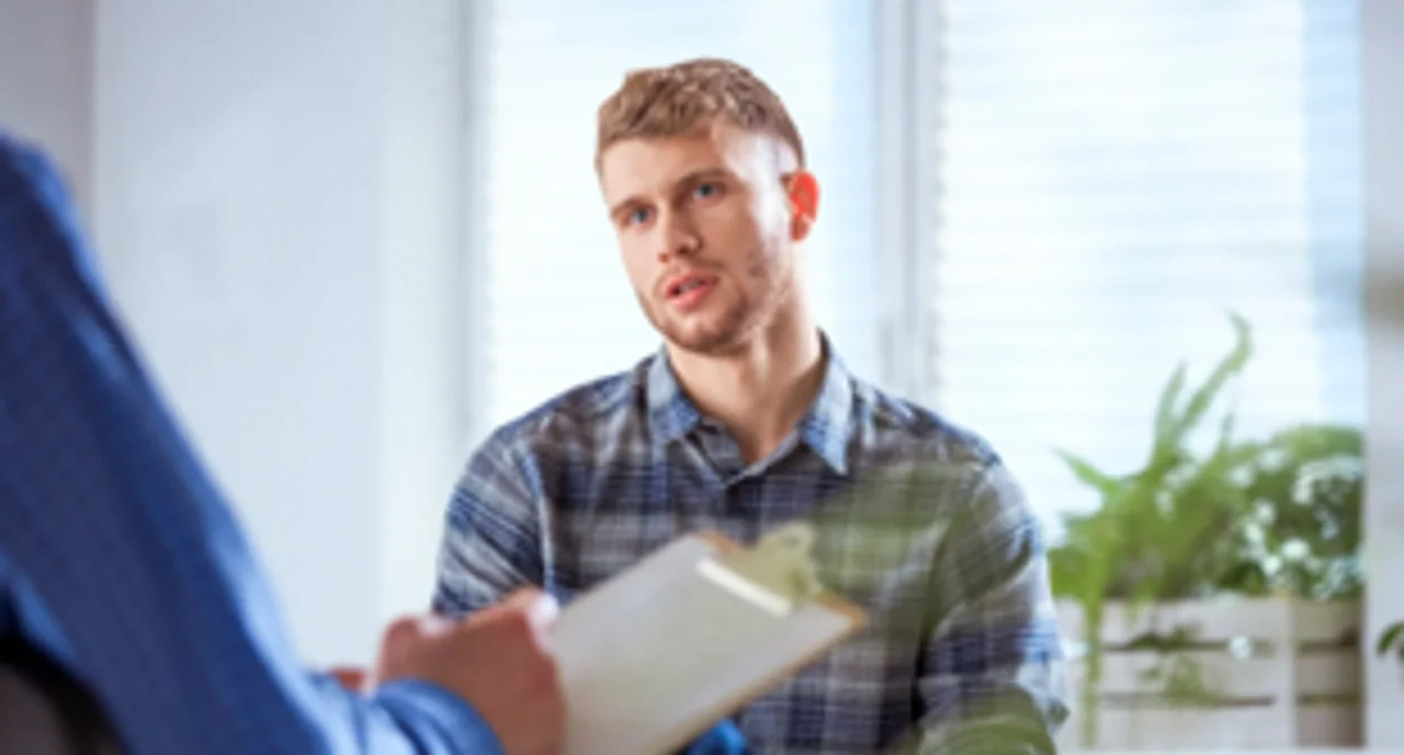 A young white man being consulted and listening intensely
